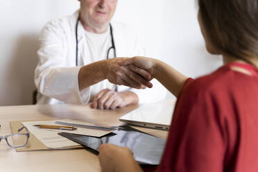 Ein Arzt schüttelt einem Patienten in einer Klinik die Hand - AFVF07120