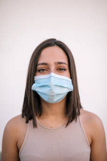 Porträt einer schönen jungen Frau mit Gesichtsschutzmaske - GRCF00337