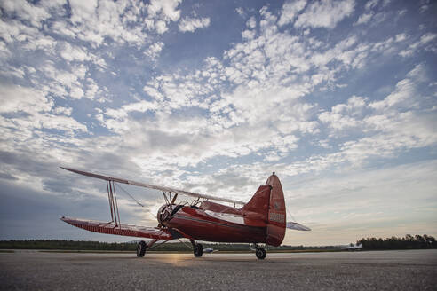 Rotes Waco-Flugzeug bei Sonnenaufgang auf der Startbahn in Maine - CAVF88608
