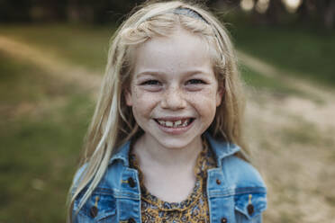 Close up portrait of school aged girl smiling outside - CAVF88620