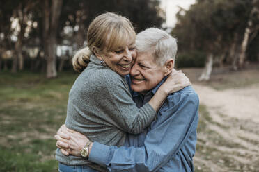 Close up portrait of senior adult couple embracing in forest - CAVF88623