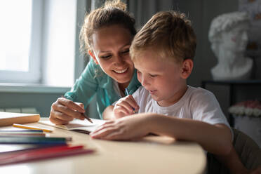 Cheerful woman drawing with boy - CAVF88630