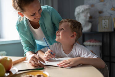 Happy mother and son drawing together - CAVF88631