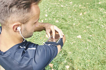 Sportsman looking at his smart phone - CAVF88656