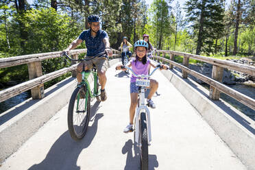 A family enjoys a bike ride on a bike path in South Lake Tahoe, CA - CAVF88699