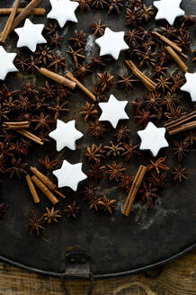 Cinnamon star cookies, cinnamon sticks and star anise on rustic baking sheet - ASF06678