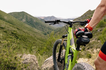 Man standing near mountain bike in forest - ADSF14066