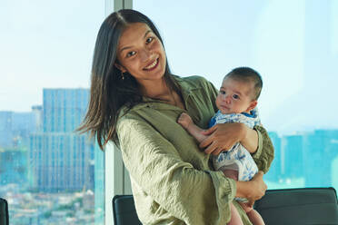 Mother holding her soon at home near the window - ADSF14191