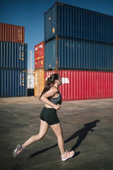 Frau beim Joggen in einem Industriegebiet - GRCF00353