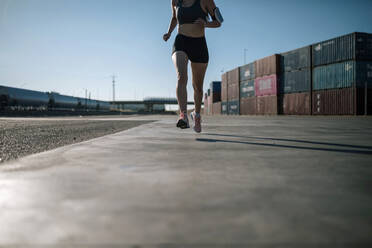 Woman jogging in an industrial park - GRCF00354