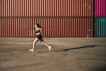 Frau beim Joggen in einem Industriegebiet - GRCF00358