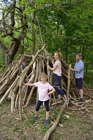 Happy family building camp with log in forest stock photo