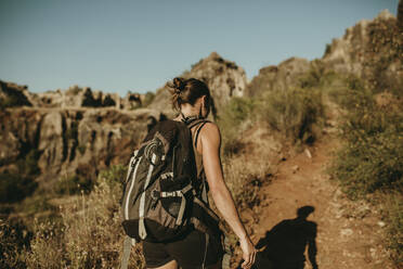 Woman with backpack hiking in forest - DMGF00141