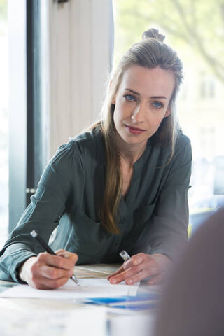 Woman working at desk in office stock photo