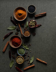 Top view composition with different kinds of natural aromatic spices placed on dark gray background - ADSF14262