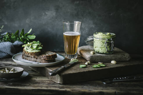 Toasts mit grüner Cashewpastete und Gurkenscheiben auf Holzbrett - ADSF14313