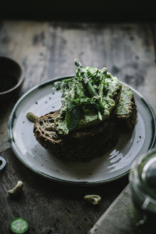 Von oben Toasts mit grüner Cashewpastete und Gurkenscheiben auf Holzbrett - ADSF14315