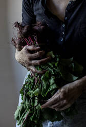 Faceless person with bunch of beetroots and key - ADSF14319