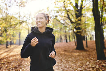 Junge Frau joggt im Herbstwald - BSZF01684