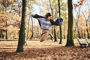 Junge Frau springt im Herbstwald - BSZF01713