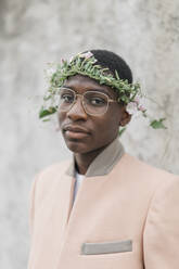 Junger Mann mit Brille und Blumen-Tiara auf der Stirn - KMKF01462
