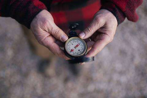 Ausgeschnittenes Bild eines Buschwanderers, der beim Wandern einen Navigationskompass hält, lizenzfreies Stockfoto