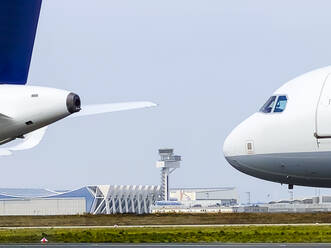 Airplanes on runway against clear sky at airport - WEF00472