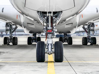 Ansicht von Flugzeugreifen auf der Startbahn eines Flughafens von unten - WEF00478