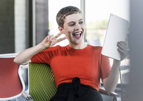 Glückliche Geschäftsfrau mit Tablet im Büro - UUF21152