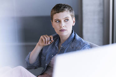 Businesswoman thinking at desk in office - UUF21176