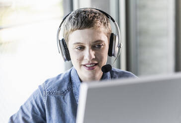 Geschäftsfrau mit Headset am Schreibtisch im Büro - UUF21183