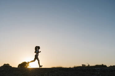 Silhouette of woman running against clear sky during sunset - EGAF00690