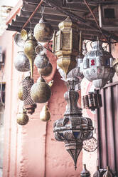 Set of assorted traditional Arabic lanterns hanging on roof outside shabby building - ADSF14559