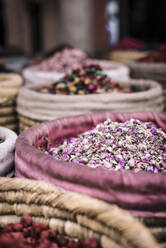 Wicker baskets with dried herbs placed on market on street of Marrakesh, Morocco - ADSF14713