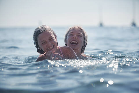 Mädchen spielen im Meer im Sommer, lizenzfreies Stockfoto