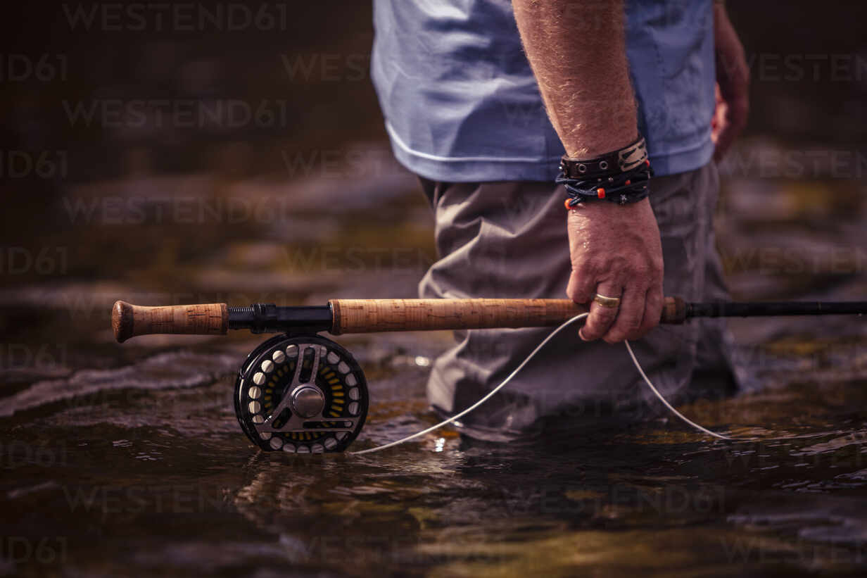 Close-up of fisherman hand holding fishing rod in hand while