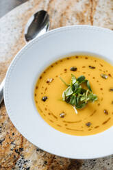 Von oben schmackhafte, appetitliche Gemüsecremesuppe in weißem Teller am Tisch im Cafe - ADSF14727