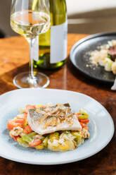 From above of fillet fish with small square slices of peppers on plate in restaurant - ADSF14735