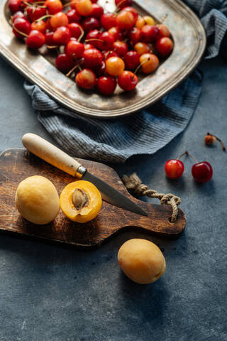 Flat lay of delicious cherry and yellow peach served on plate on a rustic background stock photo