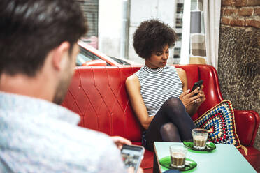 Couple using smart phones while sitting in coffee shop - EHF00812