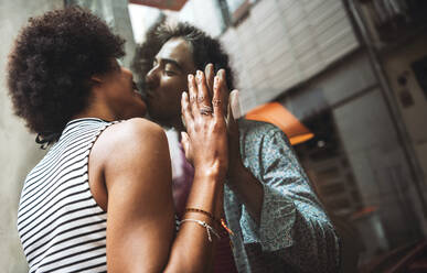 Romantic woman kissing boyfriend through window of coffee shop while standing outdoors - EHF00833