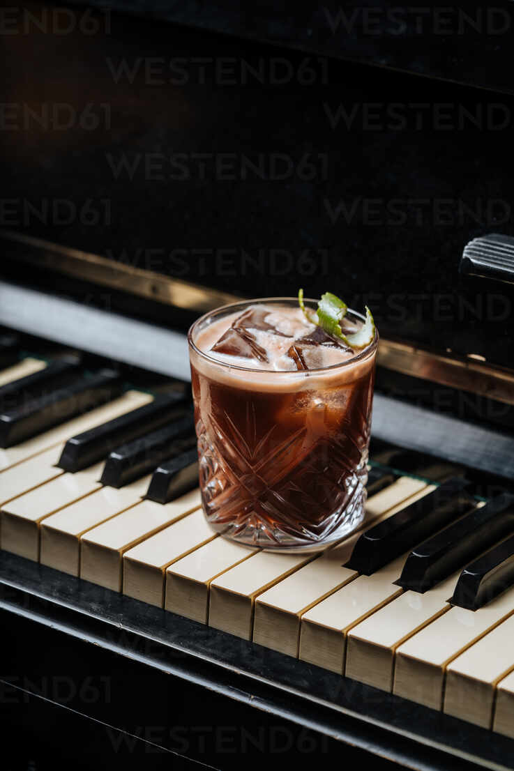 https://us.images.westend61.de/0001449942pw/glass-of-cocktail-with-ice-resting-on-a-piano-keys-ADSF14845.jpg
