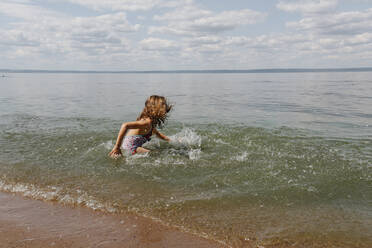 Kleines Mädchen genießt beim Spielen im Wasser am Strand - OGF00492