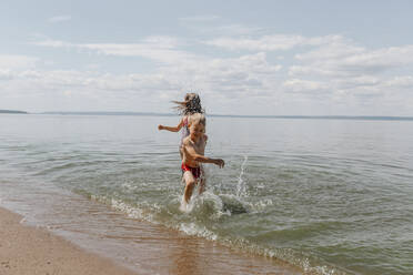 Bruder und Schwester haben Spaß im Sommer am Strand - OGF00493