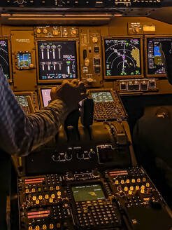Hand einer Person, die einen Hebel im Flugsimulator Boeing 747-400 betätigt - WEF00481
