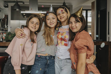 Smiling girls standing in birthday party at home - MFF06136