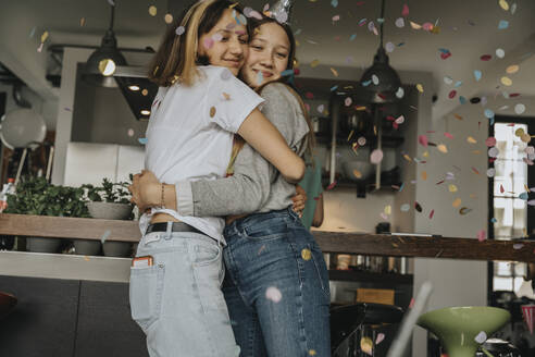 Verliebte Teenager-Freunde, die sich umarmen, während sie auf einer Geburtstagsfeier zu Hause stehen - MFF06137