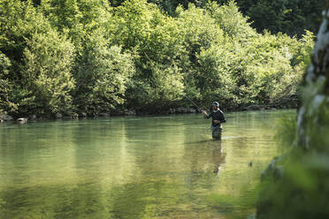 Man fly-fishing in green river - DHEF00363