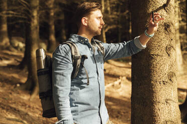 Mittlerer Erwachsener, der im Wald stehend mit seinem Mobiltelefon fotografiert - BOYF01571