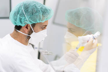 Close-up of male pharmacist making medicines in laboratory - DGOF01347